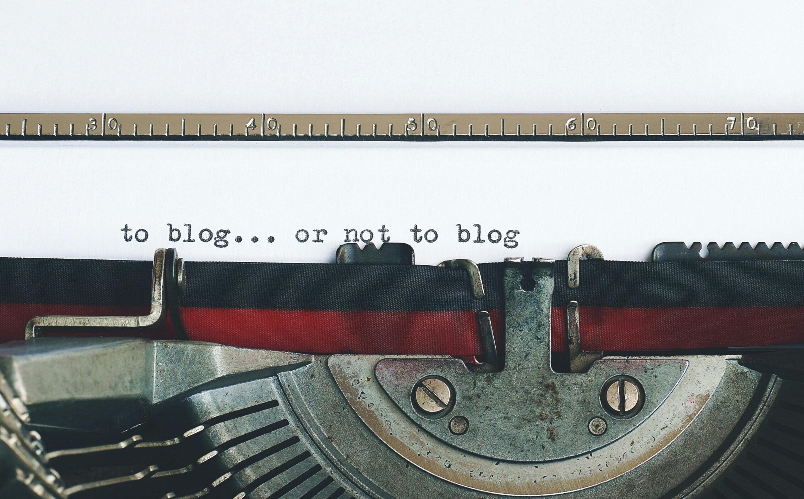 Typewriter with paper displaying "to blog... or not to blog," symbolizing content creation and digital marketing strategies for healthcare practices.