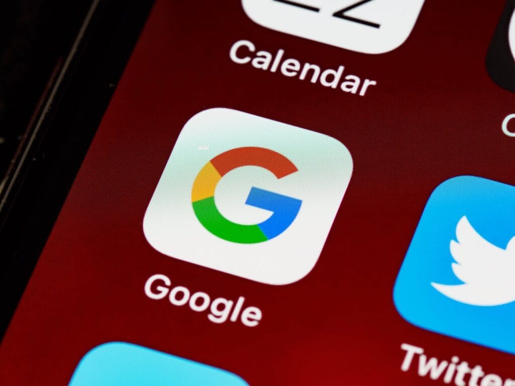 Google app icon on smartphone screen among social media icons, highlighting digital marketing tools for enhancing online visibility in dental practices.