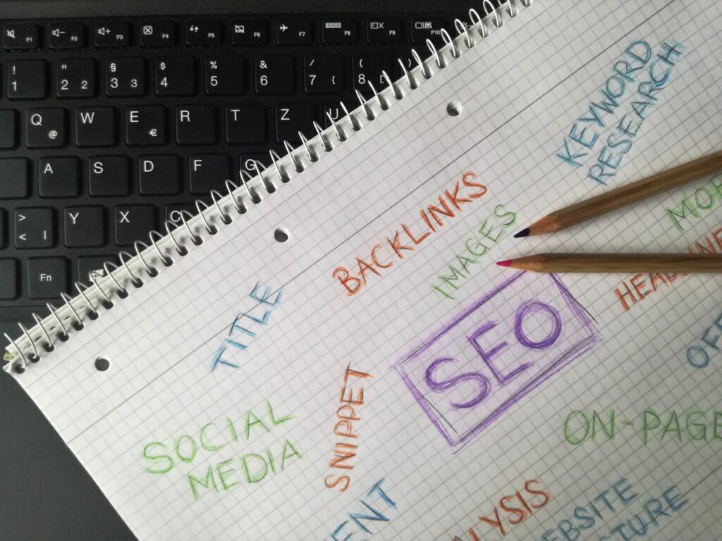 SEO strategy concepts on a notepad, featuring keywords like "SEO," "backlinks," "keyword research," and "social media," with pencils on a laptop keyboard, illustrating digital marketing for healthcare practices.